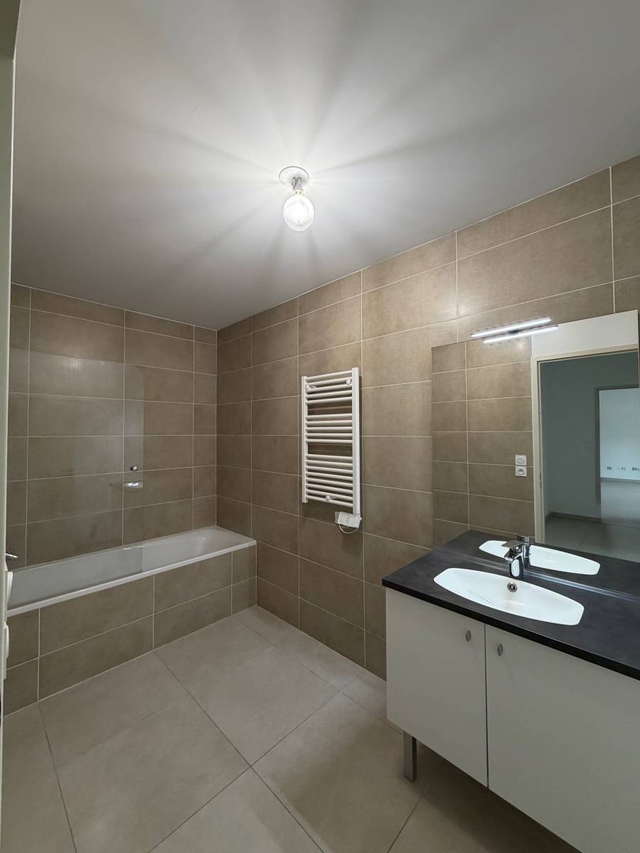 Salle de bain avec baignoire, sèche serviette avec placard